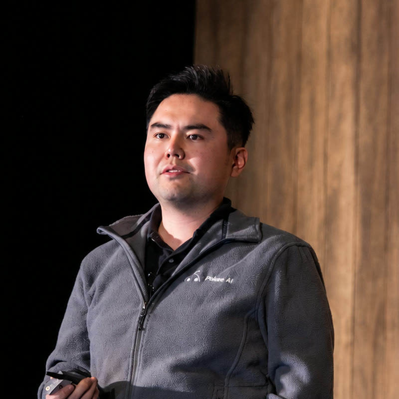 Zheqing (Bill) Zhu, Founder and CEO of Pokee AI, speaking on stage.